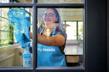 merry maid cleaning a window